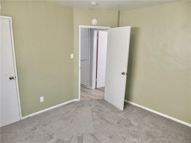 unfurnished bedroom featuring carpet floors and baseboards