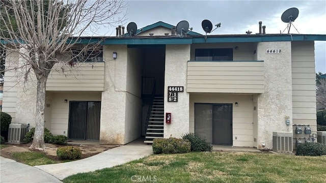 view of property with stairway and cooling unit