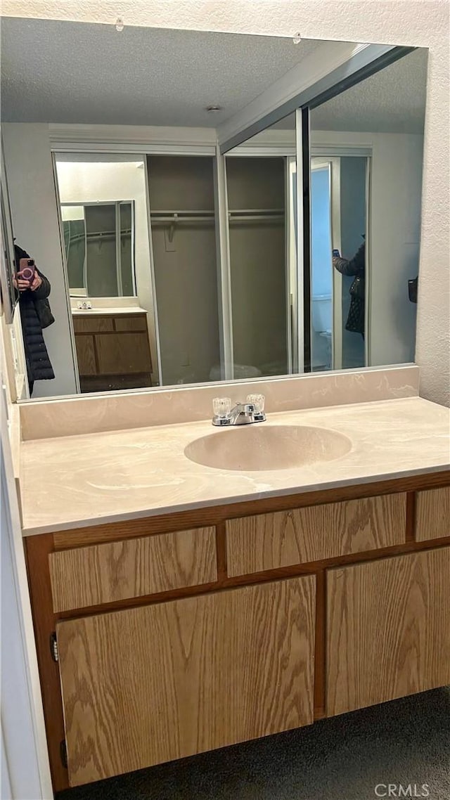 bathroom with a textured ceiling and vanity