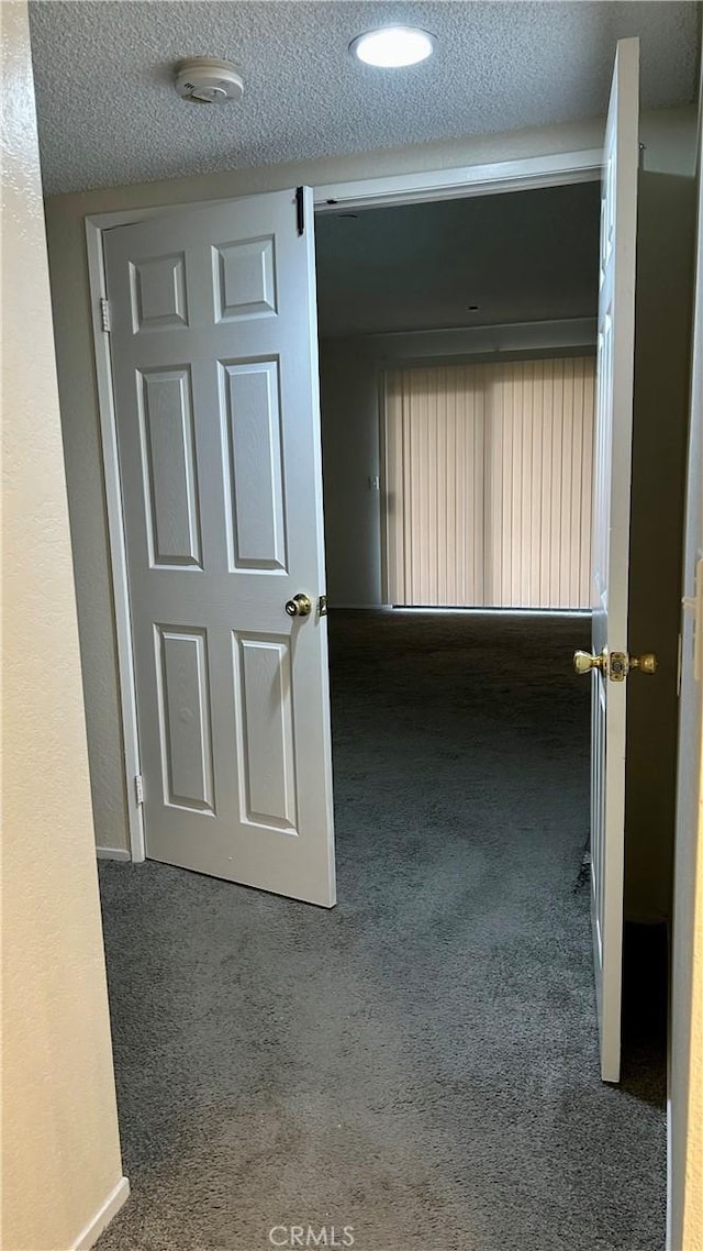 corridor featuring carpet and a textured ceiling