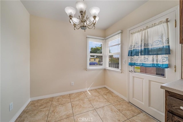 unfurnished dining area featuring an inviting chandelier, baseboards, and light tile patterned flooring