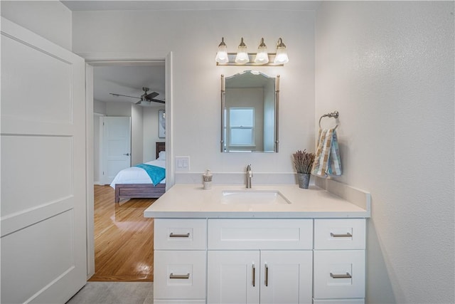 bathroom with ceiling fan, ensuite bathroom, wood finished floors, and vanity