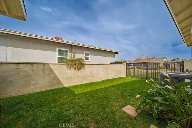 view of yard with central AC unit and fence