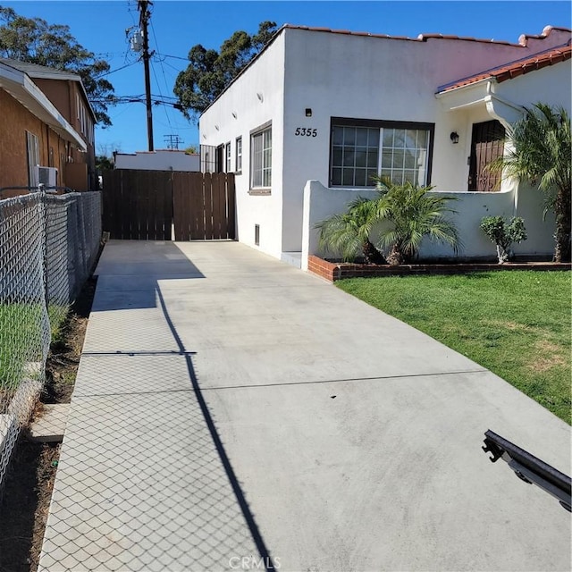 view of front of house with fence, a front lawn, and stucco siding