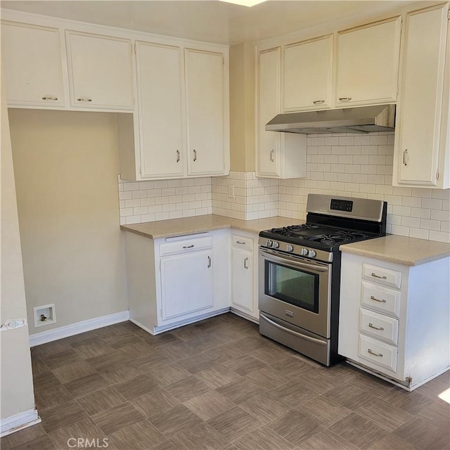 kitchen with stainless steel gas range, light countertops, under cabinet range hood, and decorative backsplash