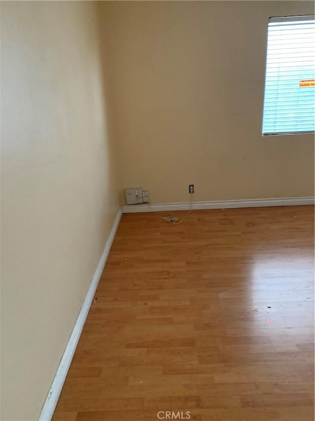 unfurnished room with light wood-style flooring and baseboards