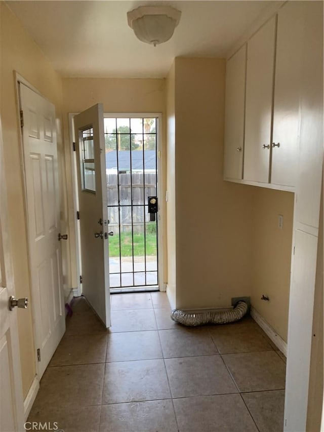 entryway with baseboards and light tile patterned flooring