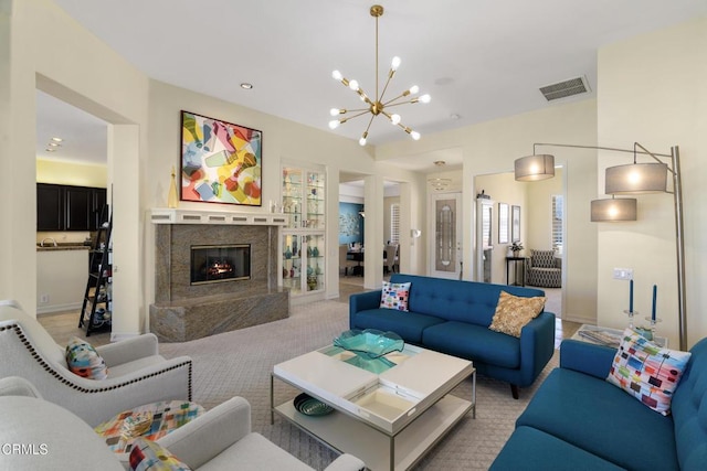 living room featuring light carpet, visible vents, built in shelves, a fireplace, and a notable chandelier