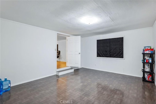 unfurnished room with parquet floors, a textured ceiling, and baseboards