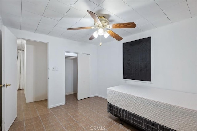 bedroom featuring ceiling fan, a closet, and baseboards