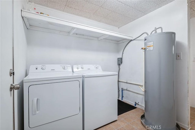 clothes washing area featuring water heater, laundry area, light tile patterned floors, and washer and dryer