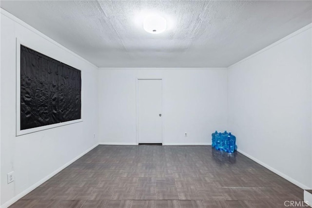 spare room featuring baseboards and a textured ceiling