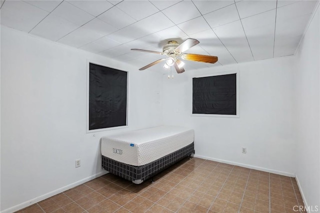 unfurnished bedroom with ceiling fan and baseboards