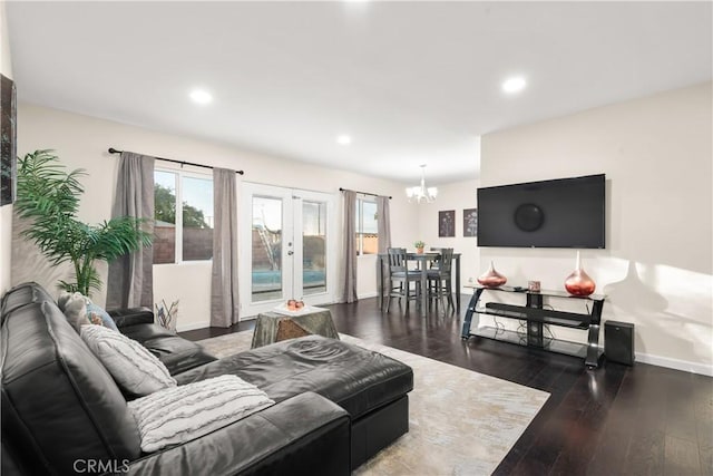 living area featuring a chandelier, a wealth of natural light, baseboards, and wood finished floors