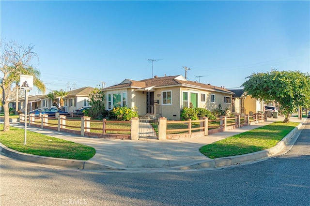 ranch-style house featuring a fenced front yard, a front lawn, and stucco siding