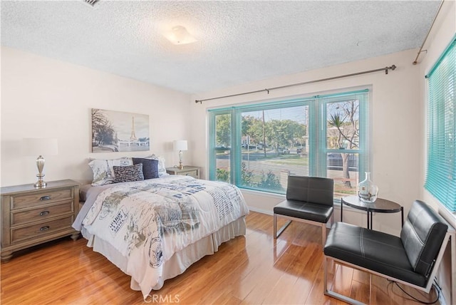 bedroom featuring light wood-type flooring and a textured ceiling