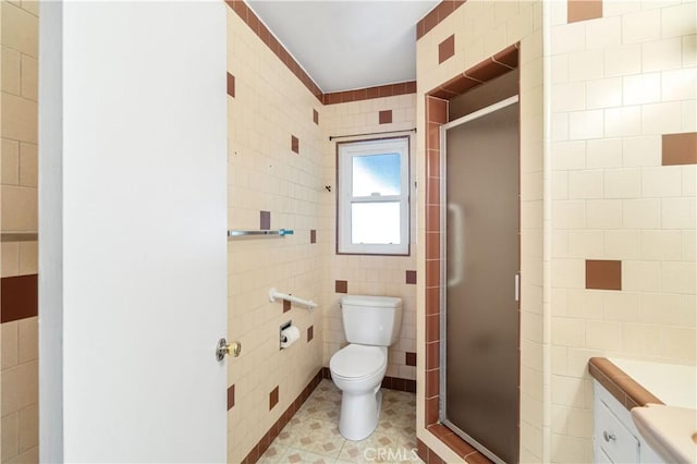 full bath with toilet, tile patterned flooring, a shower stall, and tile walls