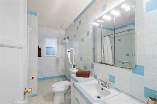 full bath with tile walls, toilet, vanity, tiled shower, and tile patterned floors