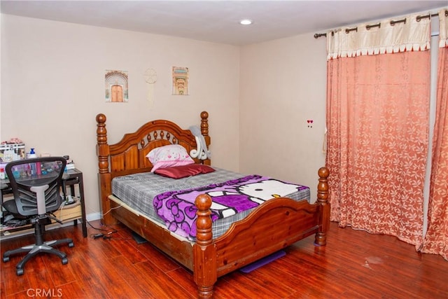 bedroom featuring baseboards, wood finished floors, and recessed lighting