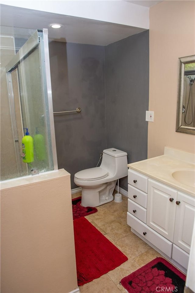 bathroom featuring a shower, tile patterned flooring, vanity, and toilet