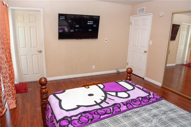 bedroom featuring visible vents, baseboards, and wood finished floors