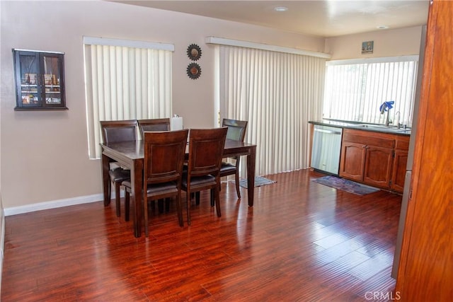 dining space with dark wood finished floors and baseboards