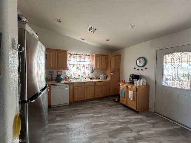 kitchen with lofted ceiling, visible vents, light countertops, freestanding refrigerator, and dishwasher