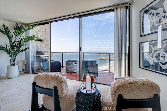 tiled living area with a wall of windows and a water view