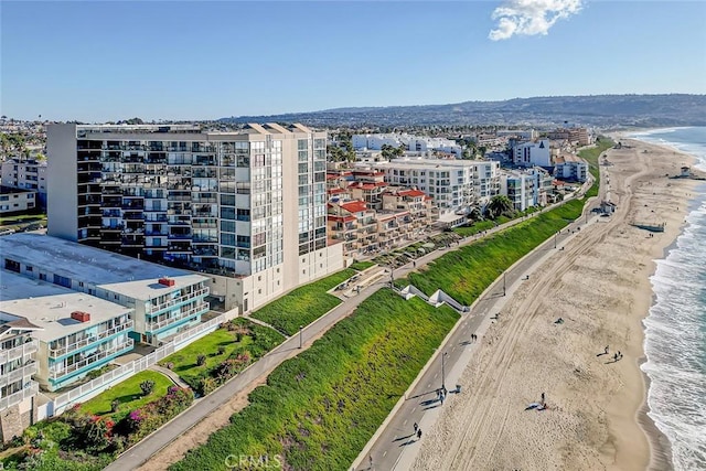 drone / aerial view featuring a view of the beach, a water view, and a city view