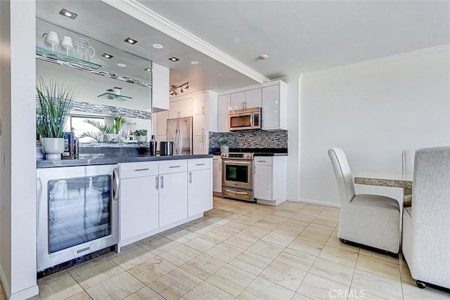 kitchen featuring beverage cooler, white cabinets, decorative backsplash, dark countertops, and stainless steel appliances