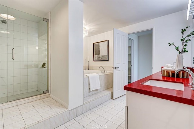 bathroom featuring a garden tub, a shower stall, tile patterned flooring, and vanity