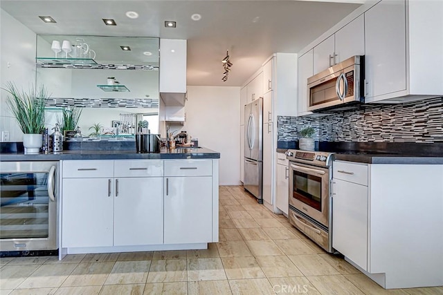 kitchen featuring white cabinets, dark countertops, wine cooler, stainless steel appliances, and backsplash