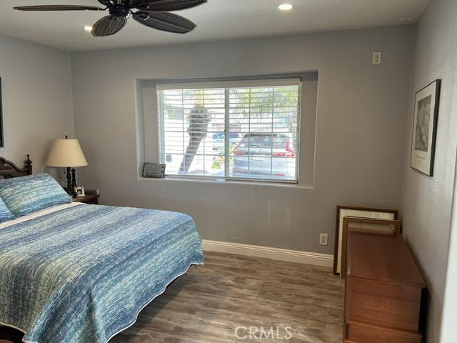 bedroom featuring a ceiling fan, baseboards, wood finished floors, and recessed lighting