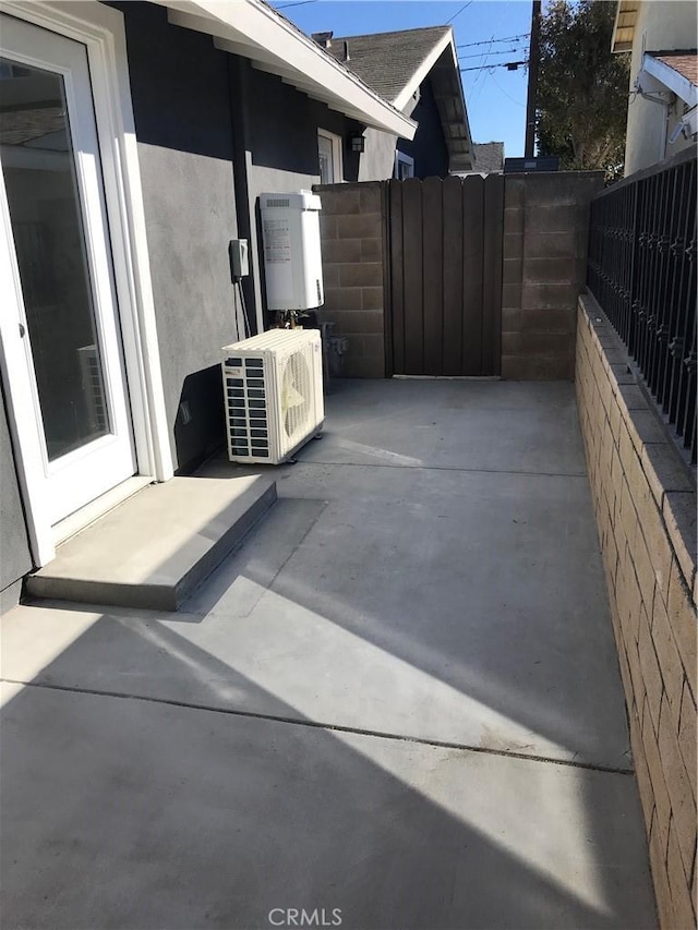 view of patio featuring ac unit, fence, and a gate