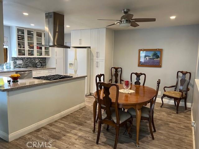 dining room with ceiling fan, baseboards, wood finished floors, and recessed lighting