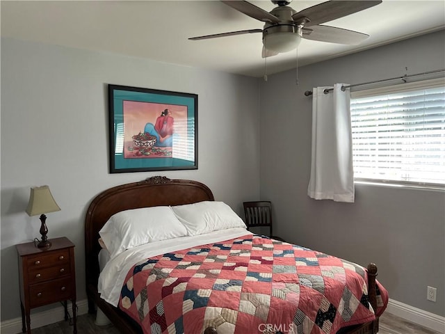 bedroom with ceiling fan, wood finished floors, and baseboards