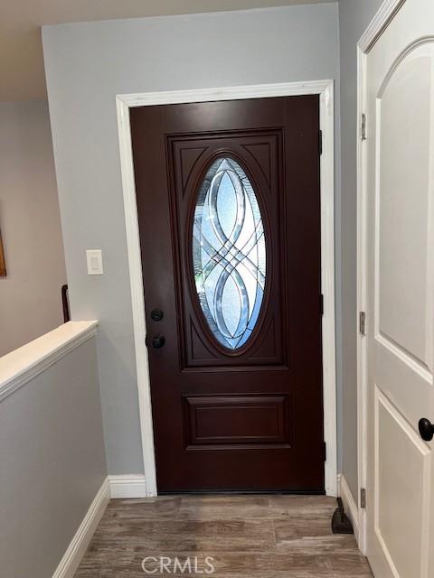 foyer entrance with baseboards and wood finished floors