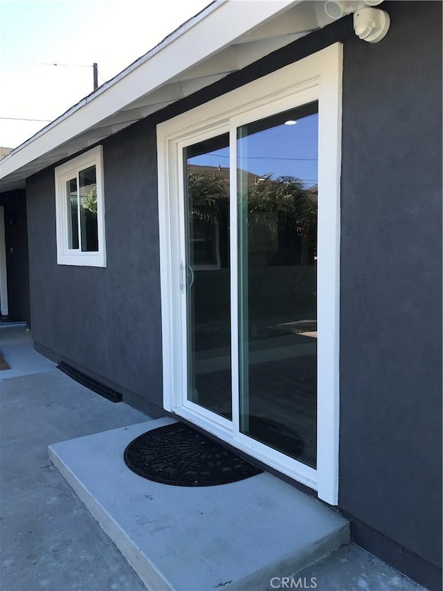 entrance to property featuring stucco siding