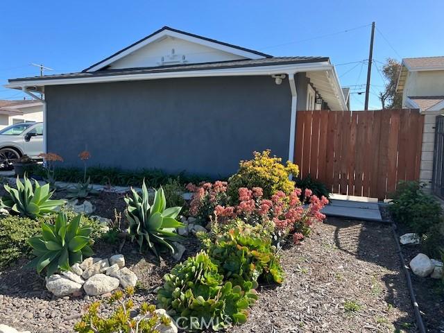 view of side of property with fence and stucco siding