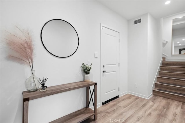 entrance foyer featuring light wood finished floors, baseboards, visible vents, stairway, and recessed lighting