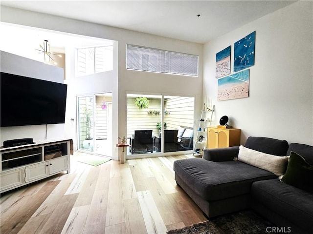 living area featuring light wood-style floors and a high ceiling