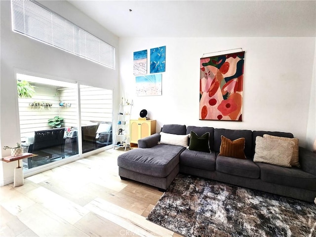 living area with high vaulted ceiling and wood finished floors