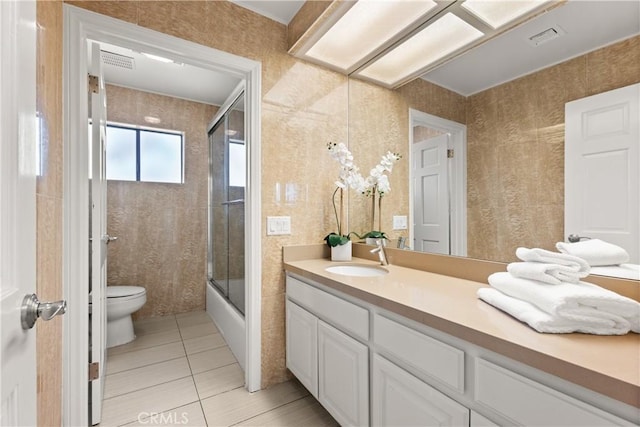 full bath with visible vents, toilet, enclosed tub / shower combo, tile patterned floors, and vanity