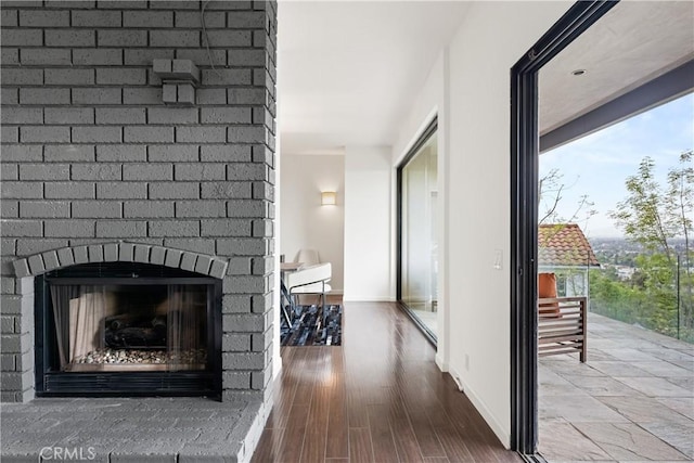 corridor featuring plenty of natural light, wood finished floors, and baseboards