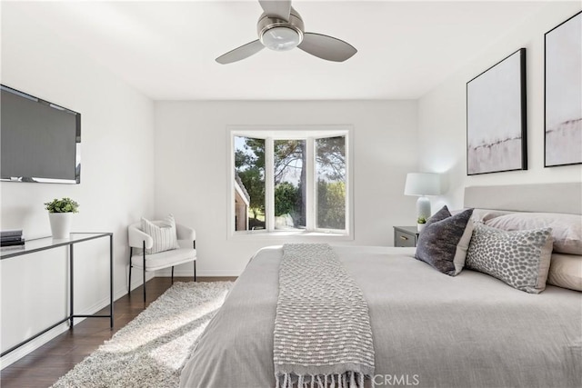 bedroom featuring ceiling fan, baseboards, and wood finished floors