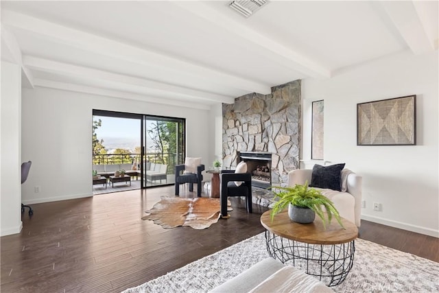 living room with visible vents, beamed ceiling, baseboards, and wood finished floors