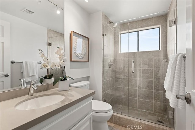 bathroom with a stall shower, visible vents, vanity, and toilet