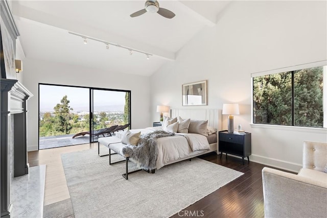 bedroom with beam ceiling, track lighting, wood finished floors, high vaulted ceiling, and baseboards