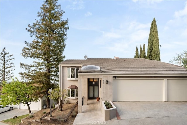 view of front of property with driveway, a garage, and stucco siding