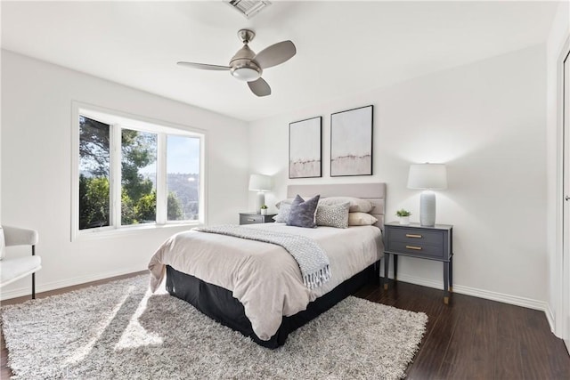 bedroom with visible vents, dark wood finished floors, baseboards, and ceiling fan